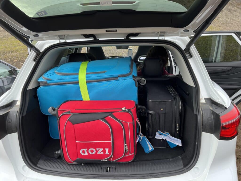 A trunk of a car full of suitcases.