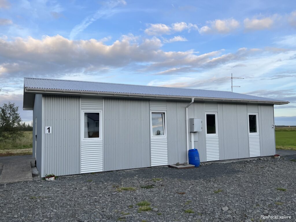 a grey rectangular shape guesthouse with white doors in Iceland.