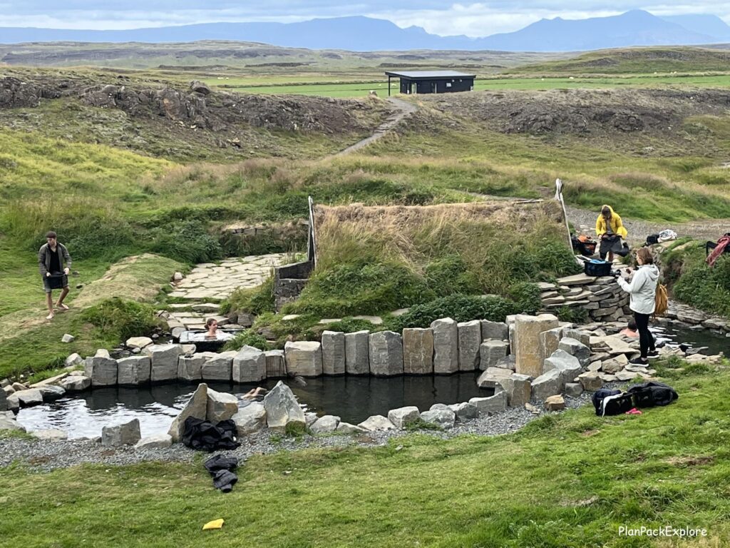 Hrunalaug natural hot spring in Iceland. A small round pool with stone walls.