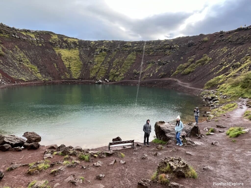 Family near the lake at the bottom of Kerid Crater in Iceland.