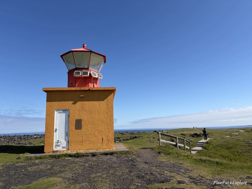 A small square orange lighthouse on Snaefellsnes Peninsula in Iceland.