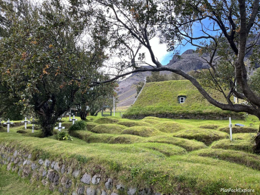 Hofskirkja - a turf church in South Iceland with grass covered burial mounds next to it.
