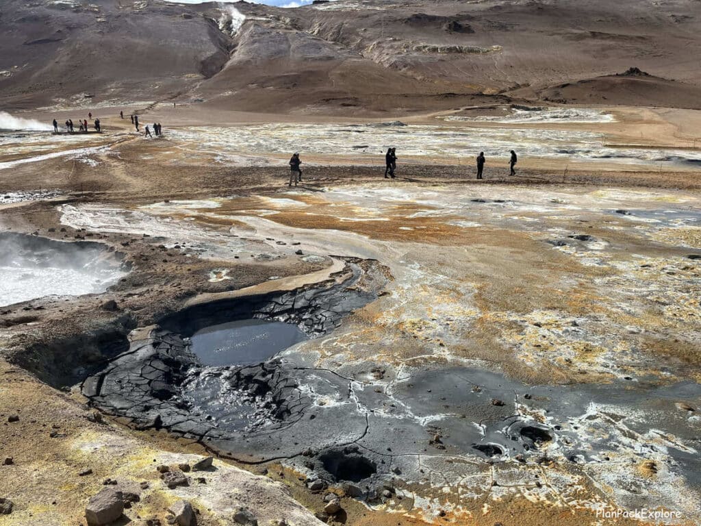 Hverir Geothermal Area and Mt. Namafjall near Lake Myvatn, Iceland. Steaming vents and mud pools in golden colored soil.