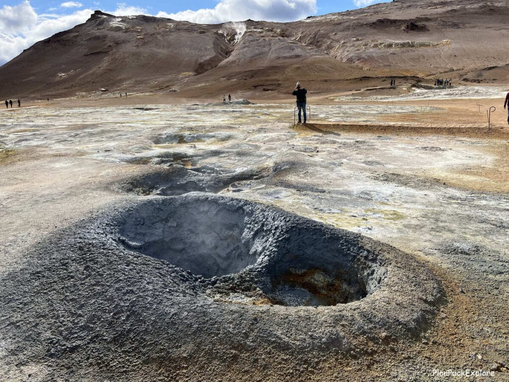 Hverir Geothermal Area and Mt. Namafjall near Lake Myvatn, Iceland. Steaming vents and mud pools in golden colored soil.