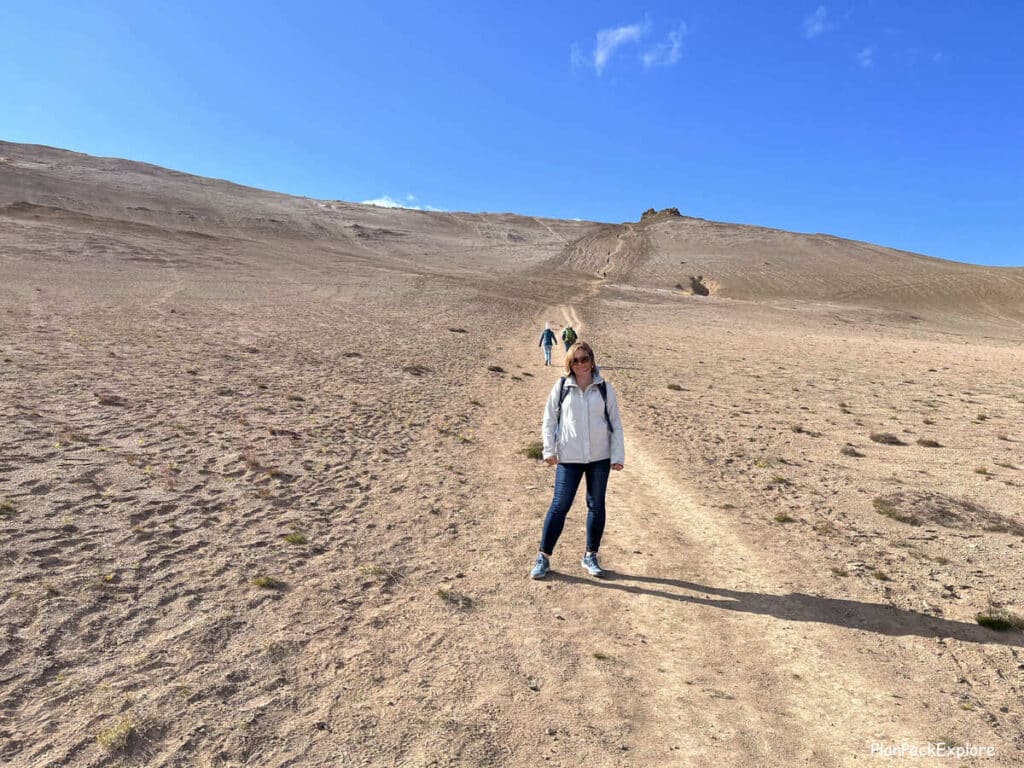 Hverir Geothermal Area and Mt. Namafjall near Lake Myvatn, Iceland. A woman on the trail on Mt. Namafjall.