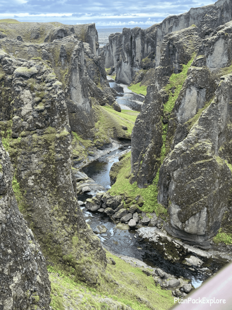 Fjadragljufur Canyon in Southeast Iceland. Moss-covered walls with a river winding at the bottom.