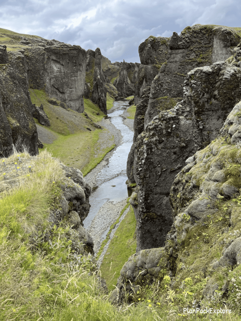Fjadragljufur Canyon in Southeast Iceland. Moss-covered walls with a river winding at the bottom.