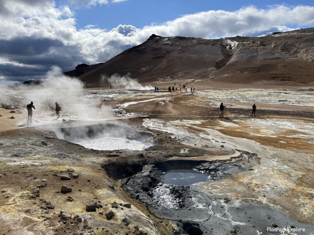 Hverir Namafjall Geothermal Area near Lake Myvatn in North Iceland - steaming vents and mud pools with a mountain in the background.