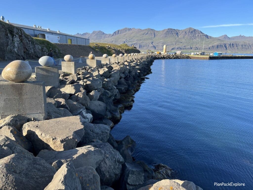 Eggin and Gledivik - large egg stone sculptures set on stone pillars in a row along the Merry bay in Djupivogur, Iceland.