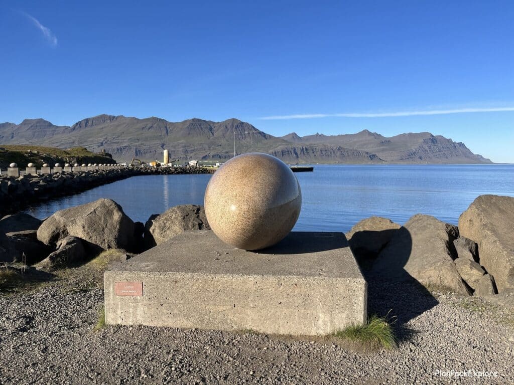 Eggin and Gledivik - large egg stone sculptures set on stone pillars in a row along the Merry bay in Djupivogur, Iceland. A sculpture of the largest egg in the center of the photo.