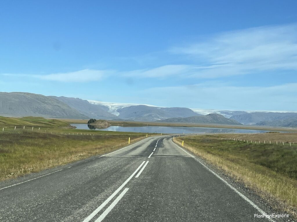 A paved road in Iceland with a glacier view ahead.
