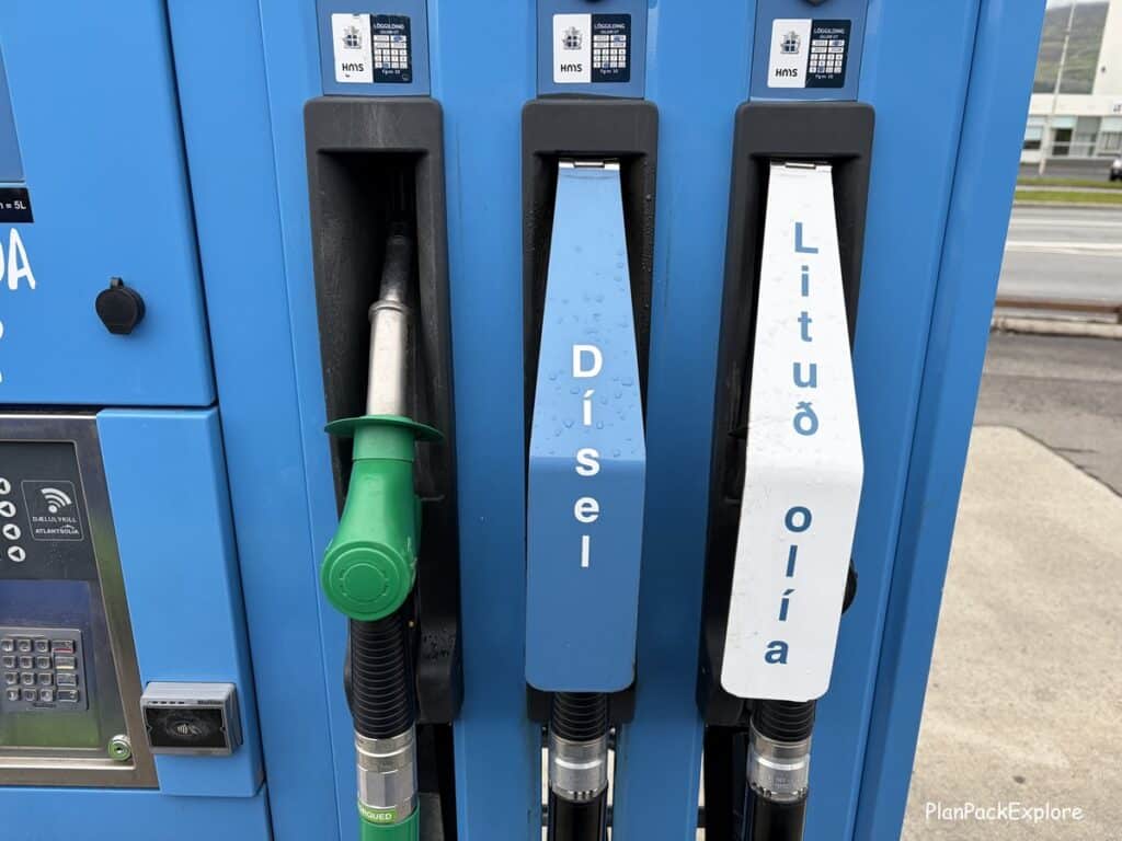A view of three fuel handles at a gas pump in Iceland.