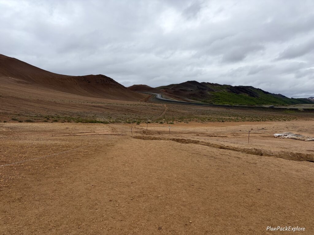 A rust-colored mountain and a road nearby, at Hverir Namafjall Geothermal Area in Iceland.