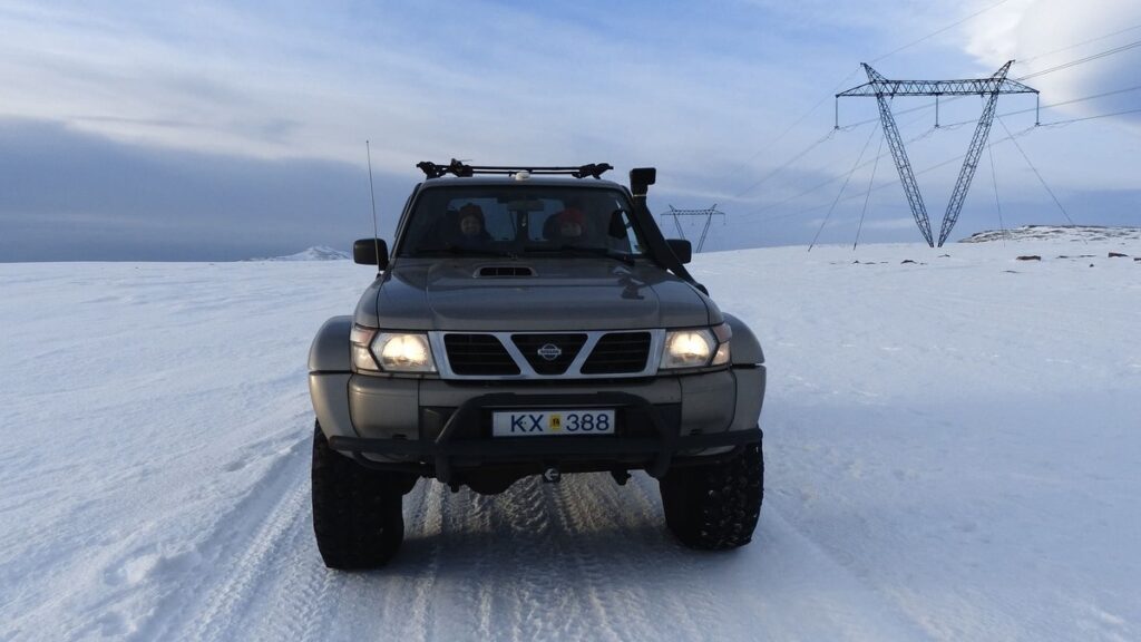 An SUV driving in the snow in Iceland.