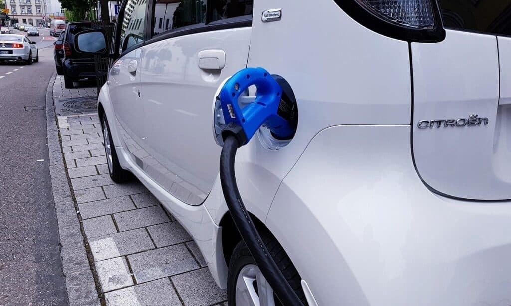 A white electric rental car charging.