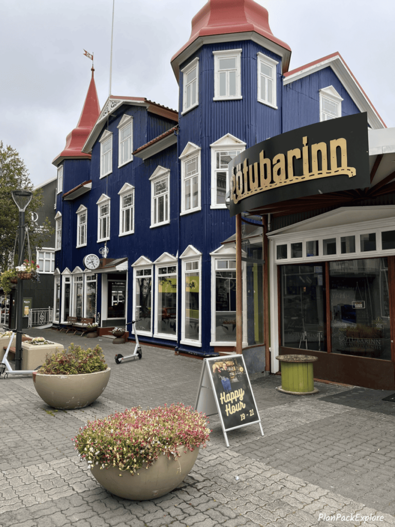 Akureyri, Iceland - a navy-blue building front by the sidewalk.