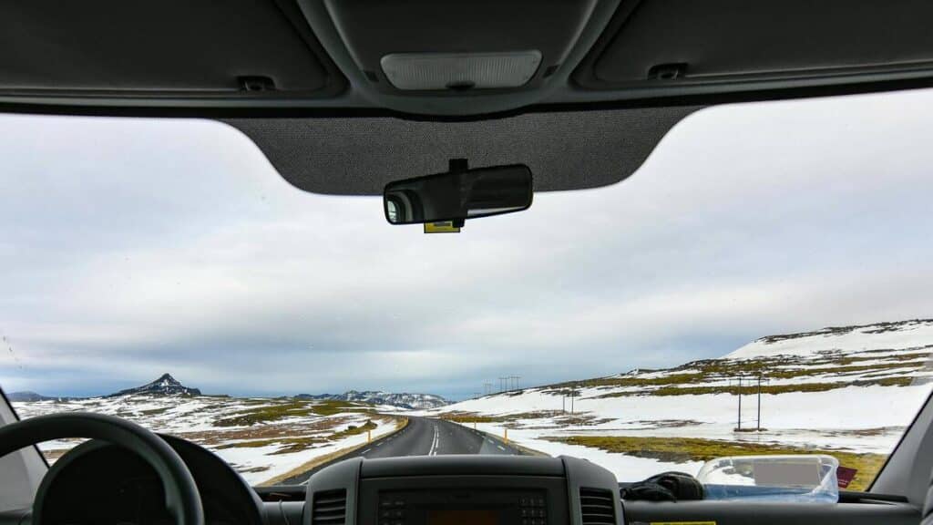 A view of the road in Iceland in the winter through the windshield of a rental car.