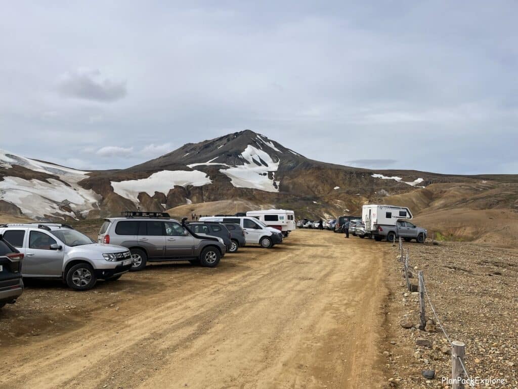 Dirt parking lot in front of the colorful mountains of Hveradalir Geothermal Area in Kerlingarfjoll, Iceland.