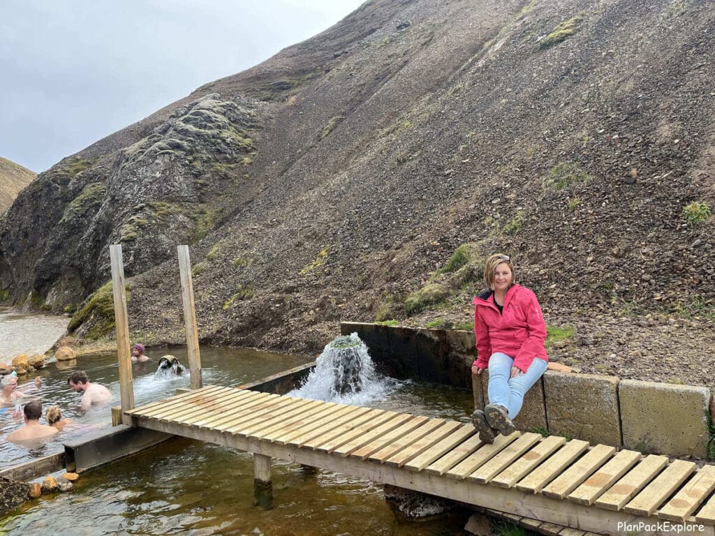 A person sitting near the hot spring at Kerlingarfjoll - a small hop pool in the mountains in Iceland.