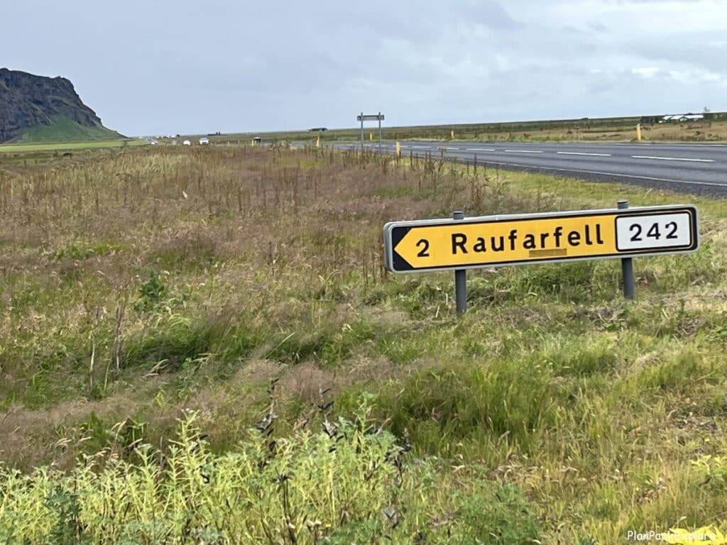 A yellow road sign for road 242 leading to Seljavallalaug swimming pool in Iceland.