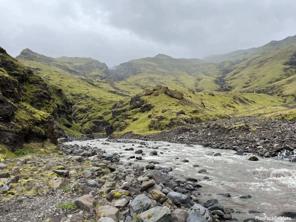 A shallow river near a gravel path in a valley near Seljavallalaug swimming pool in Iceland.