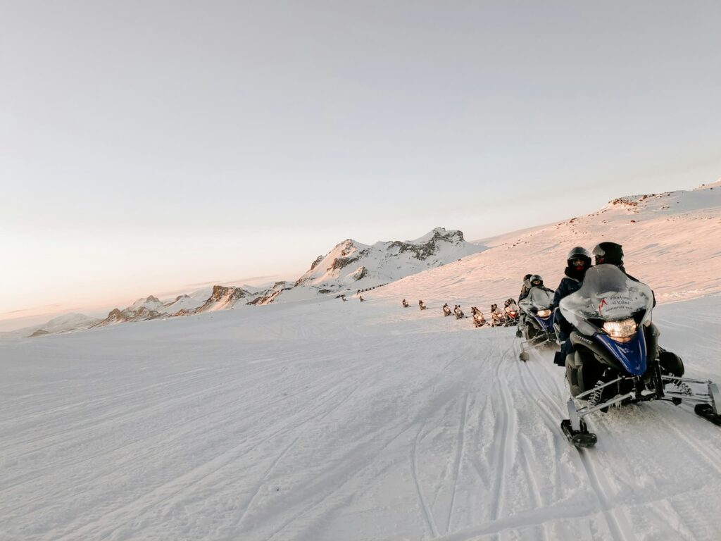 A row of snowmobiles on a glacier in Iceland.