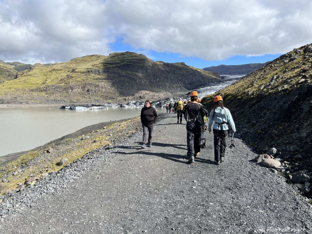 People on a gravel path to the Solheimajokull glacier in Iceland.