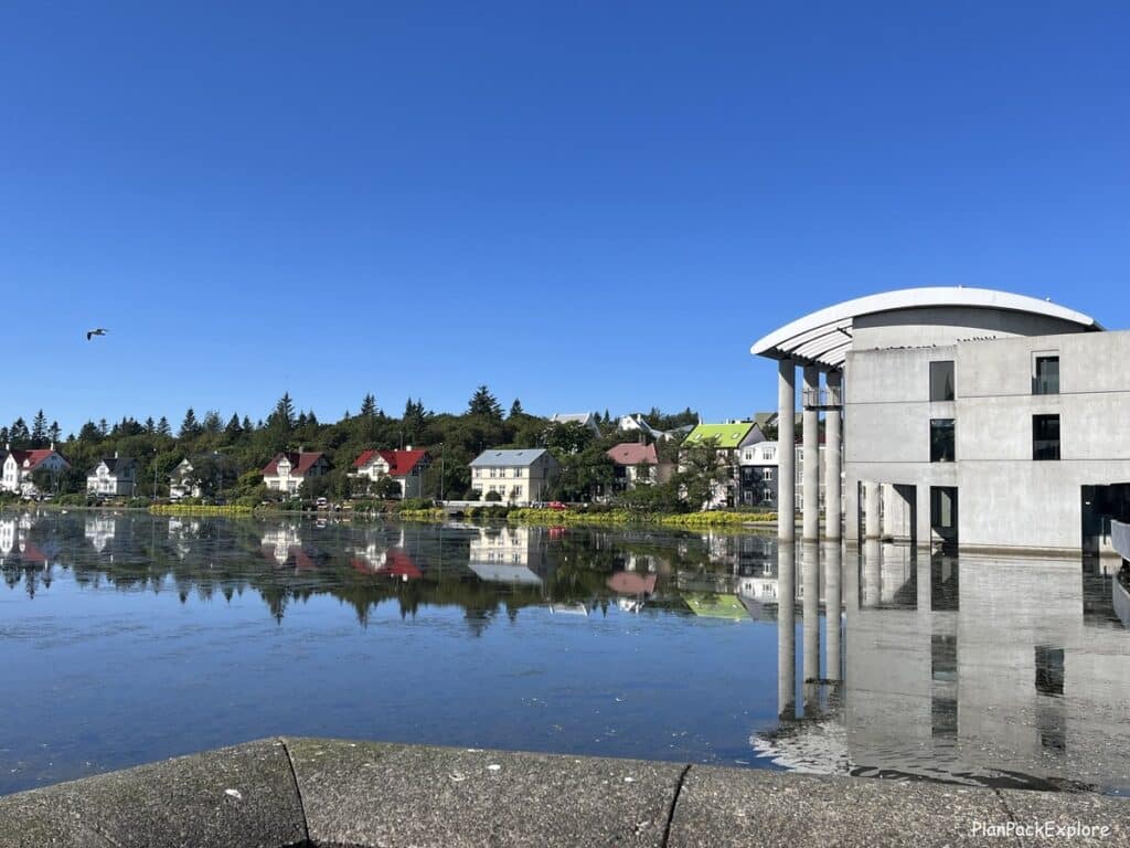 A pond near a white concrete building in Reykjavik Iceland.