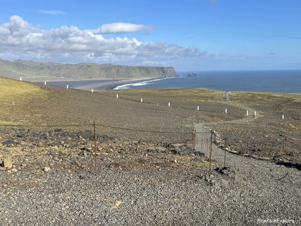 A gravel hiking trail between two levels of Dyrholaey promontory in Iceland.