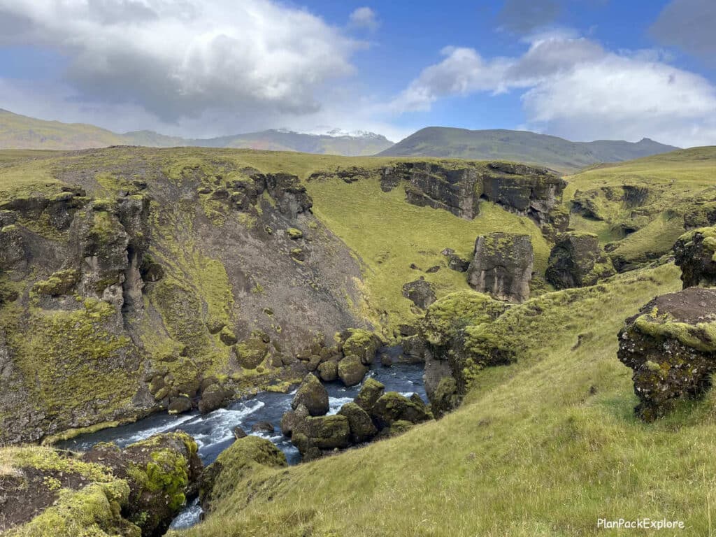 A canyon with a river and green moss-covered siden on the Skogafoss hike in Iceland.