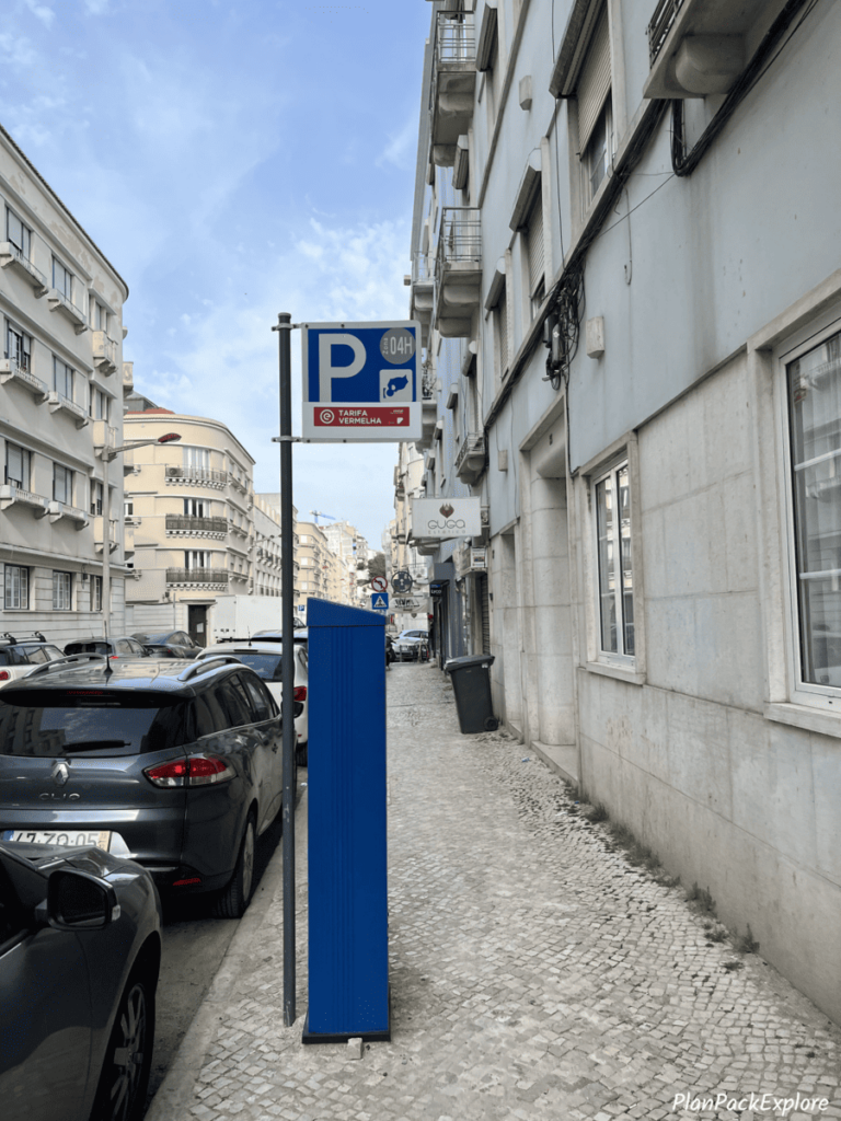 A tall blue parking meter on the side of a street in Lisbon, Portugal.