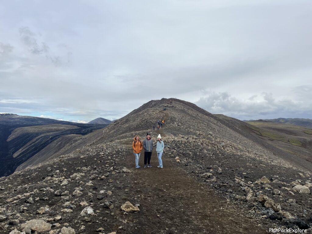 hree people on a gravel trail to the fargradasfjall volcano on Reykjanes peninsula in Iceland.