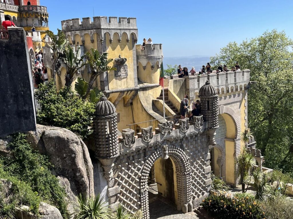 Towers and terraces with an arched entrance at Pena Palace in Sintra, Portugal.