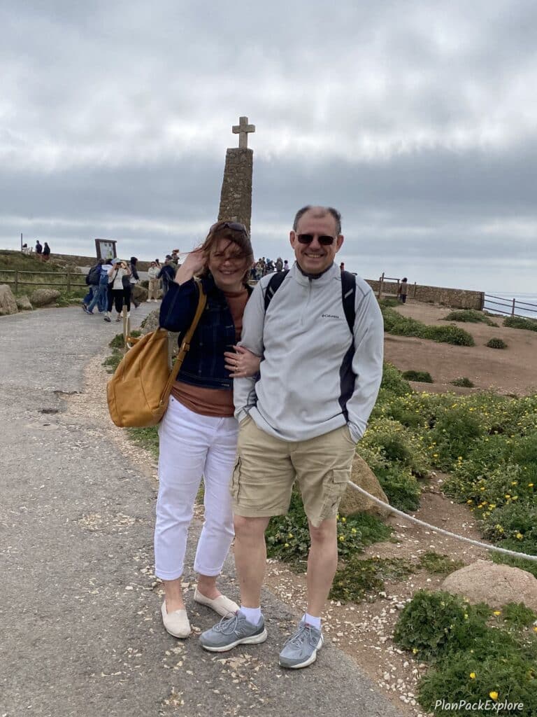 Two people standing in front of a tall monument at Cabo da Roca, Portugal