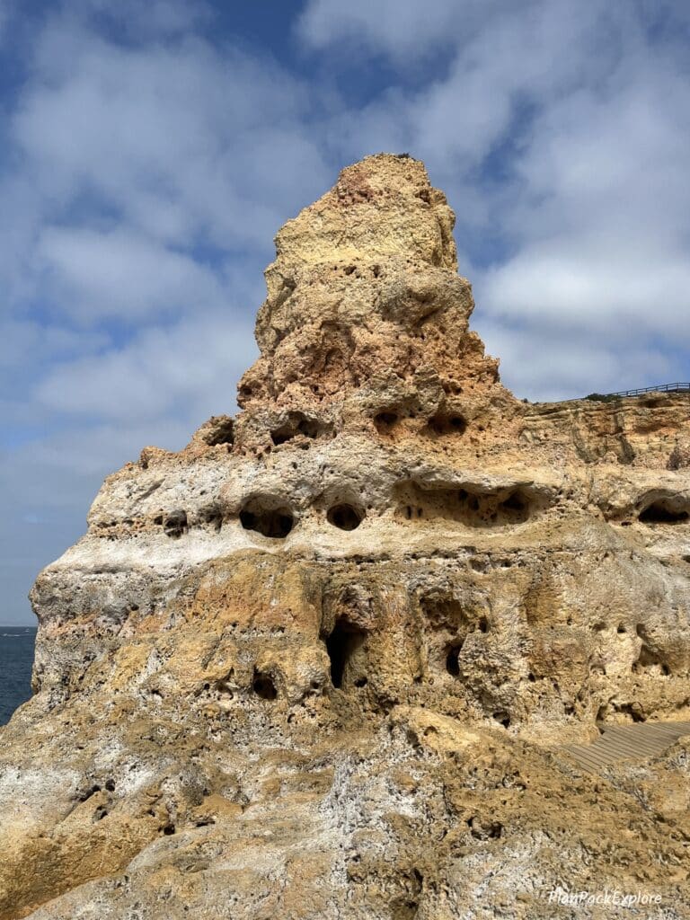 A tall pointy rock formation on the cliffs of Algar Seco in the Algarve, Portugal.