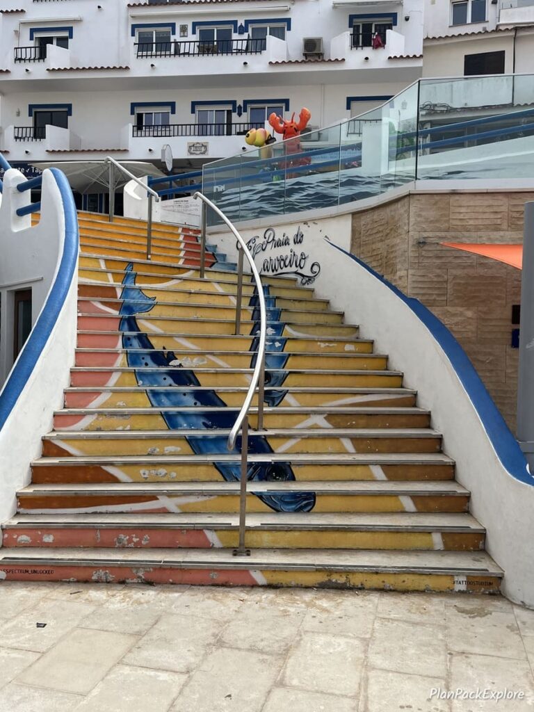 A staircase decorated with colorful tiles in Carvoeiro, Portugal.