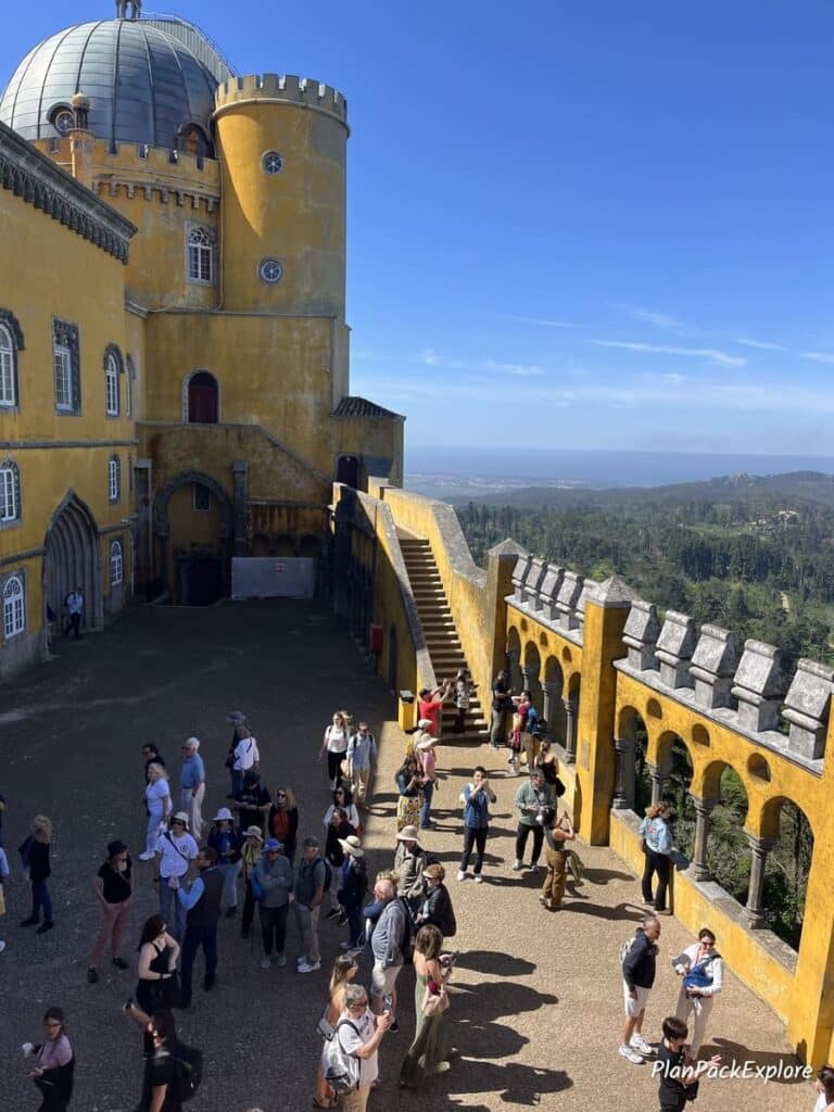 An aerial view of a terrace with tall arched windows at Pena Palace in Sintra, Portugal.