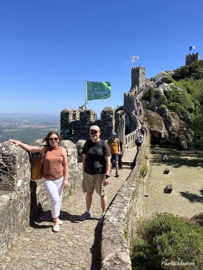 Two people on the narrow wall terrace at the Moorish castle in Sintra portugal.