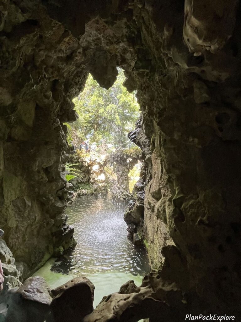 A tunnel with a view of a waterfall in Quinta da Regaleira in Sintra.