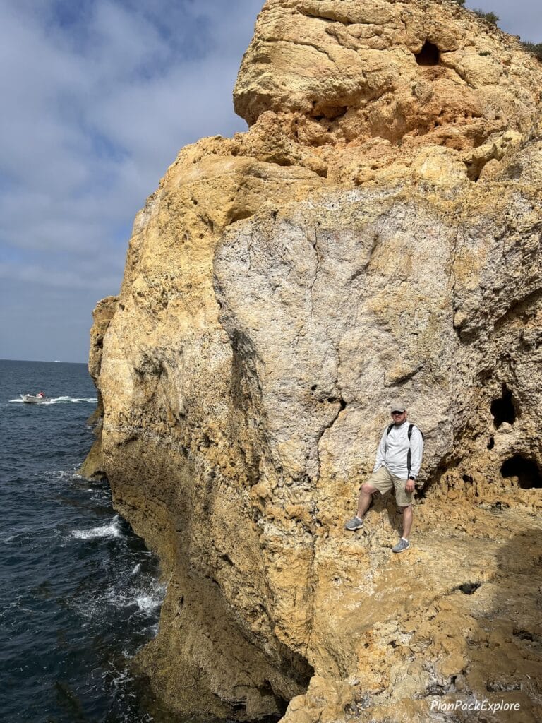a person standing at the edge of a cliff at Algar Seco, Portugal.