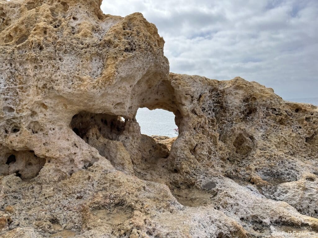 A tunnel in a limestone rocky cliff at Algar Seco in the Algarve, Portugal.