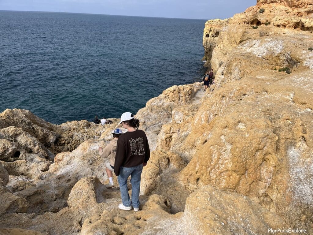 A person walking down a path along a cliff at Algar Seco in Portugal.