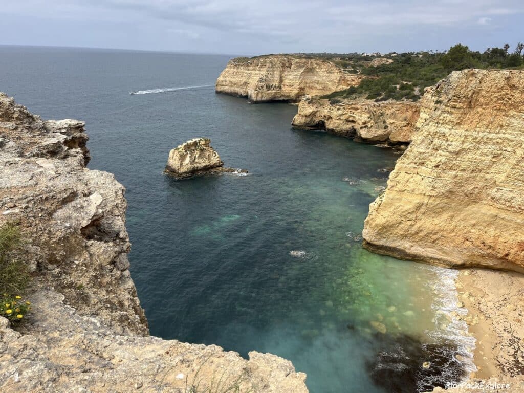 Tall cliffs and limestone structures in the ocean along the trail of the headlands in Portugal.