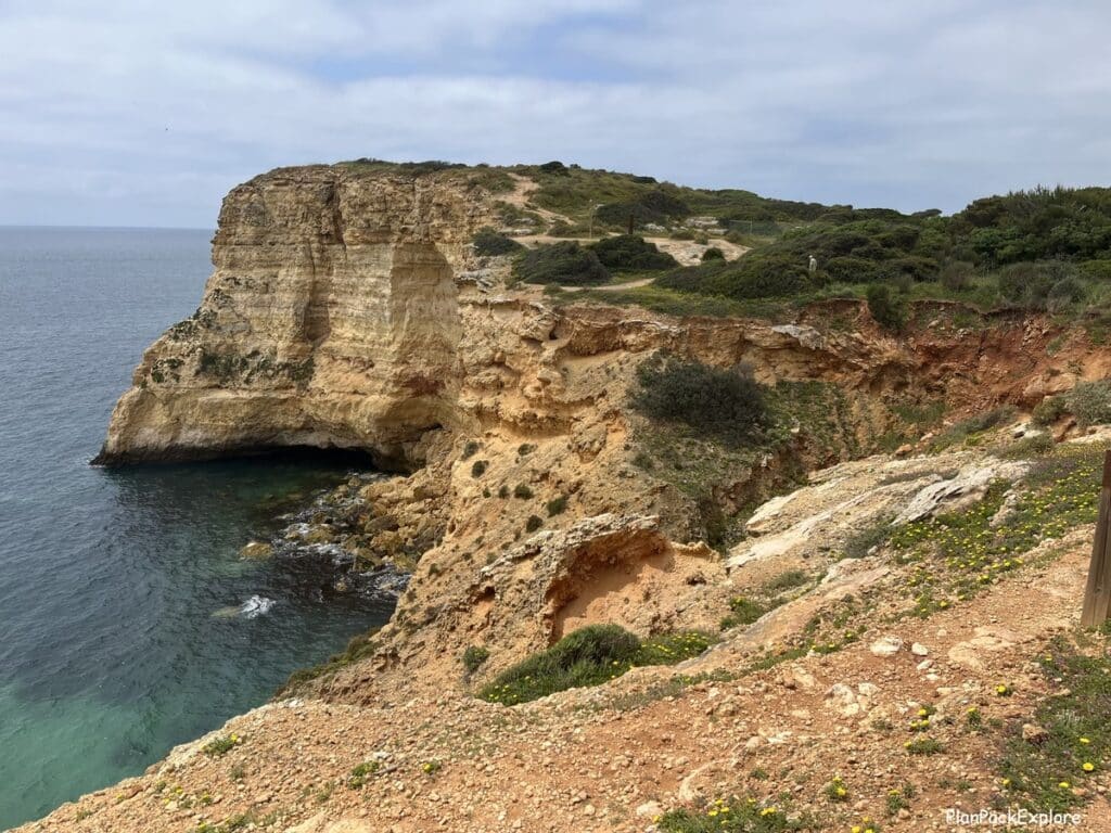 Tall limestone cliffs by the ocean along the trail of the headlands in Portugal.