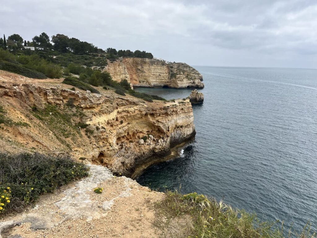 Tall limestone cliffs along the trail of the headlands in the Algarve, Portugal.