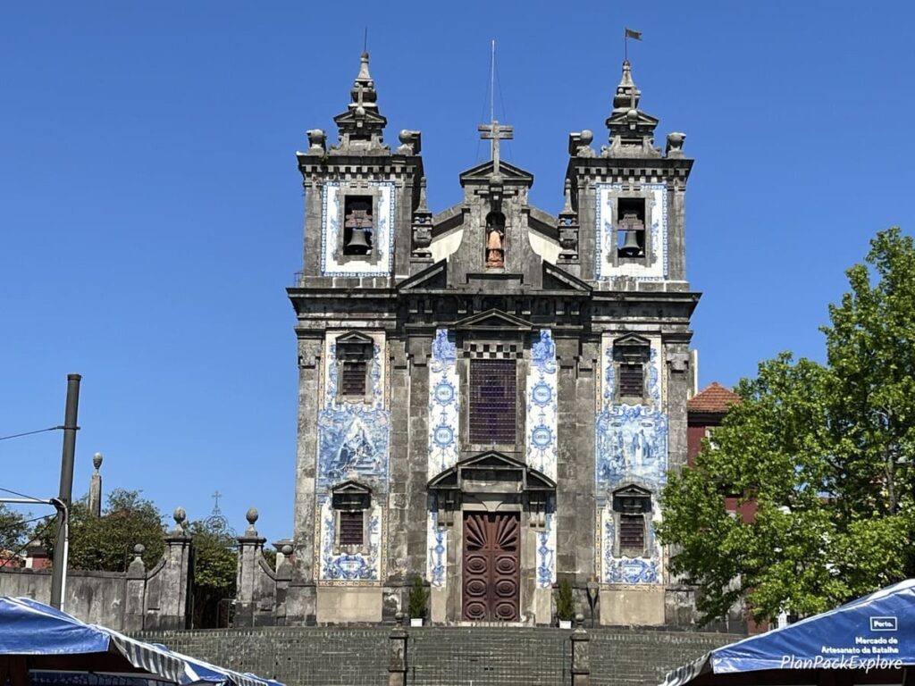 A church decorated in blue Portuguese tiles at the top of some staris in Porto.