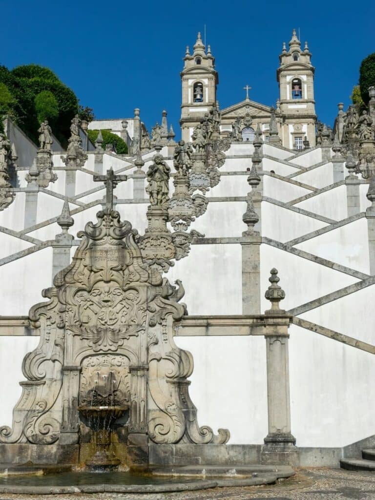 A tall tiered white building with stone trim in Braga, Portugal