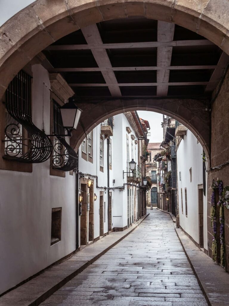 A narrow street viewed through an arch in Guimarães, Portugal.