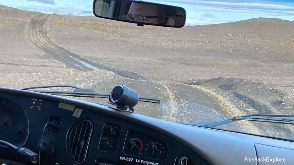 A dark winding gravel road viewed from the car window leading to laki Craters in Iceland.
