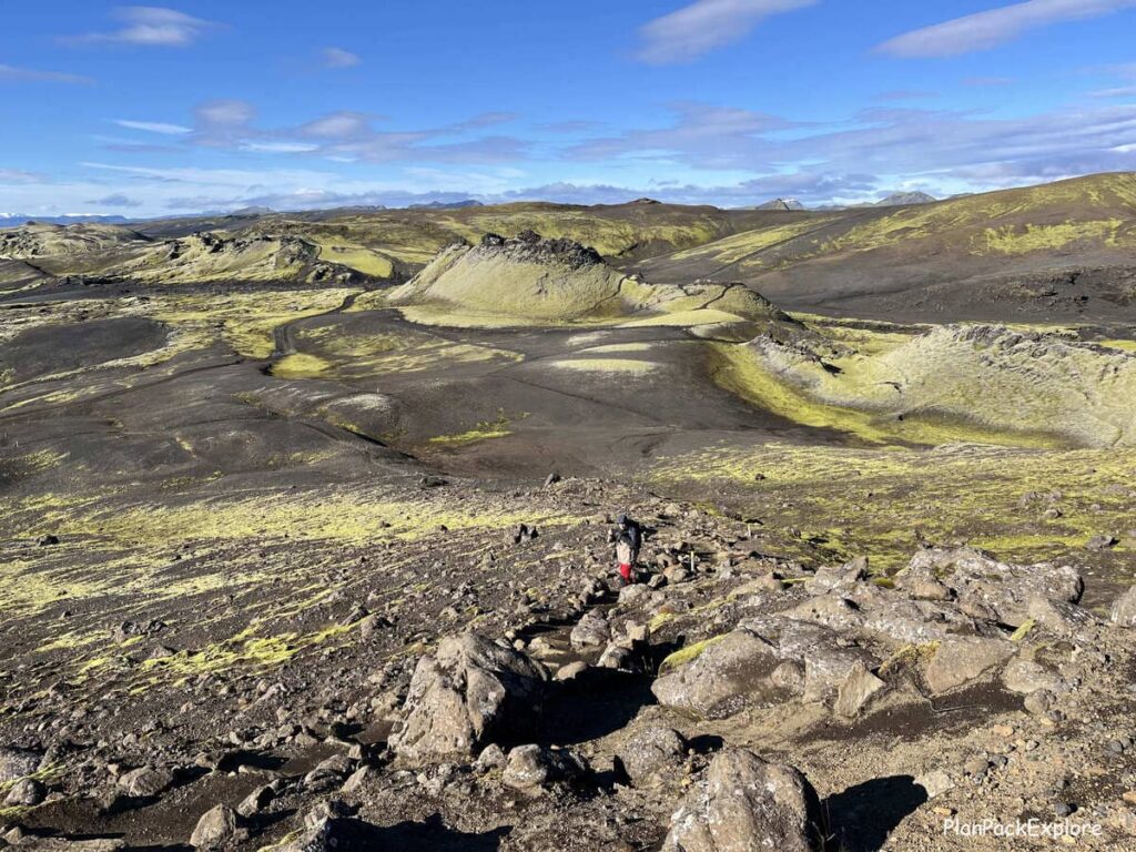 A man climbing a rocky path to Mount Laki in Iceland.